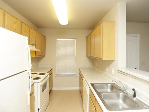 a kitchen with a stove refrigerator and sink