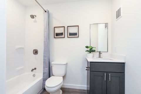 A white toilet sits next to a white sink in a bathroom.