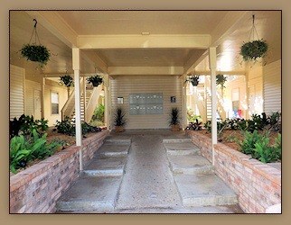A covered walkway with a stone path and plants on either side.