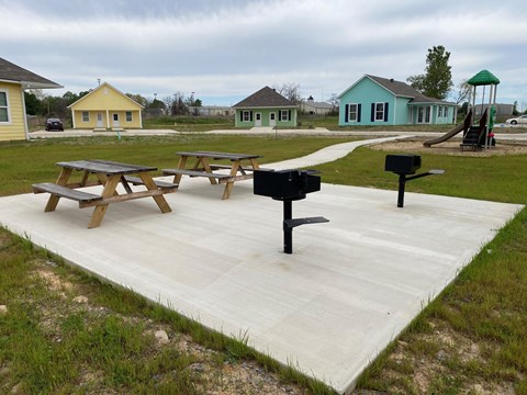 A playground with picnic tables and a swing set.