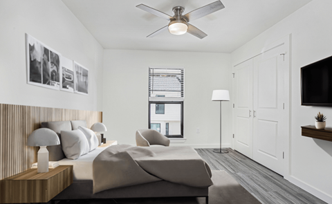 A bedroom with a large bed and a ceiling fan.