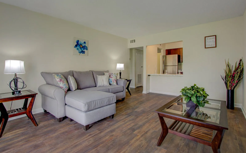 A living room with a grey couch and a wooden coffee table.