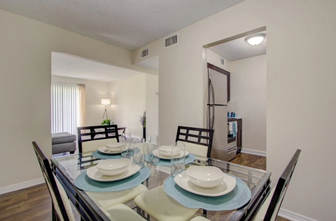 A dining room with a glass table and chairs.