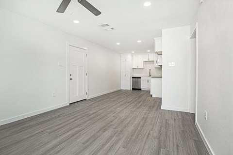 A spacious room with a ceiling fan and lighting fixtures.
