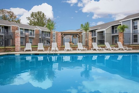 a swimming pool in front of a row of apartment buildings