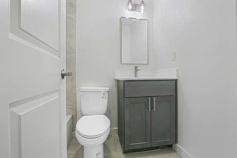 A white toilet sits next to a sink in a bathroom.