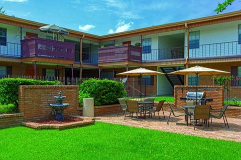 A sunny day at the apartment complex with a fountain in the courtyard.