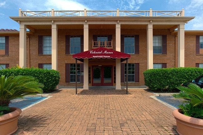 A building with a red awning that says "Valencia Apartments" in front of it.