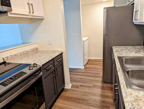 a renovated kitchen with granite counter tops and stainless steel appliances