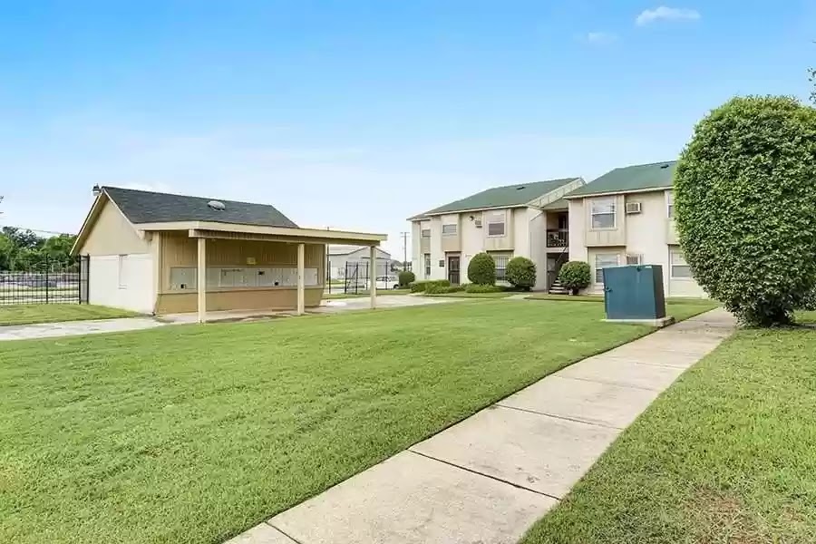A row of houses with a green lawn in front.