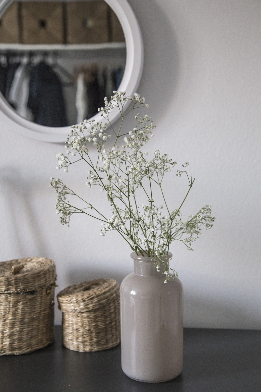 a white vase filled with white flowers on a table