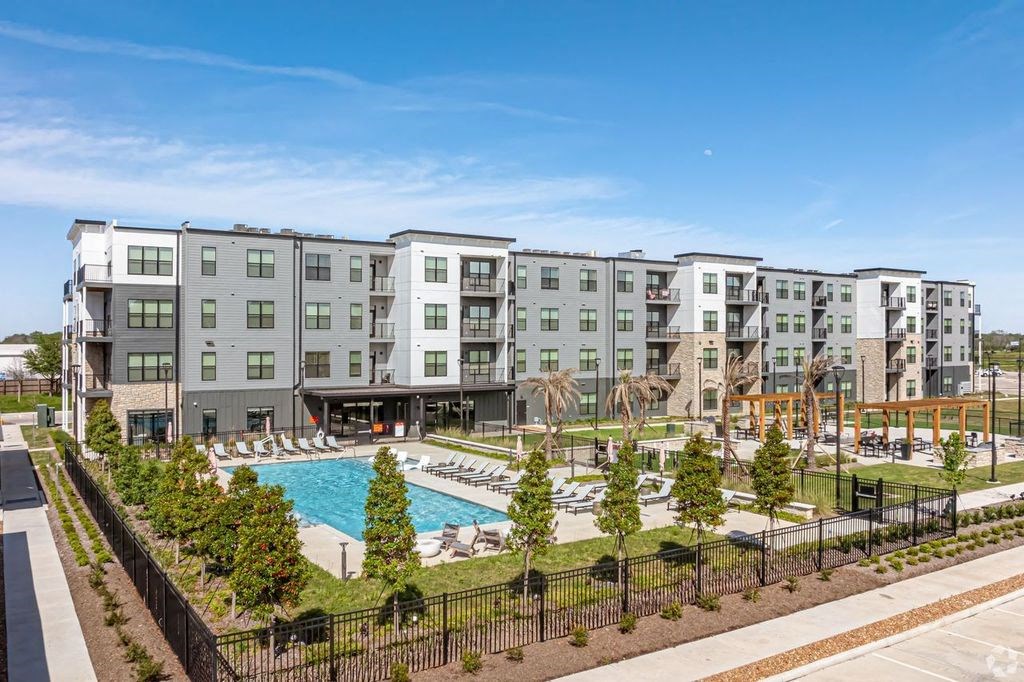 a large swimming pool in front of an apartment building