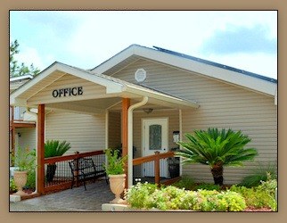 A small building with a porch and a sign that says "OFFICE".