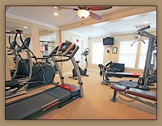 A gym with treadmills, elliptical machines and weights.