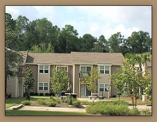 A house with a brown roof and a green lawn in front.