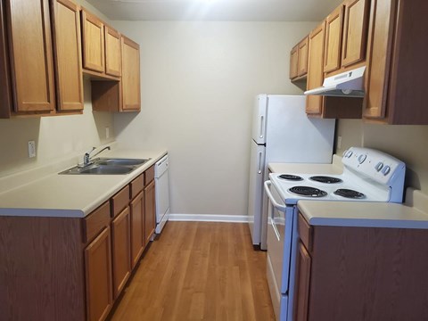 A kitchen with wooden cabinets and a white refrigerator.
