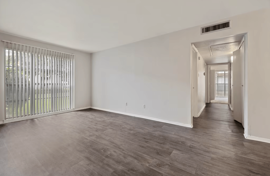 A room with a sliding door and a window with blinds.