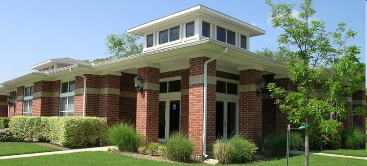 a brick office building with a lawn and trees