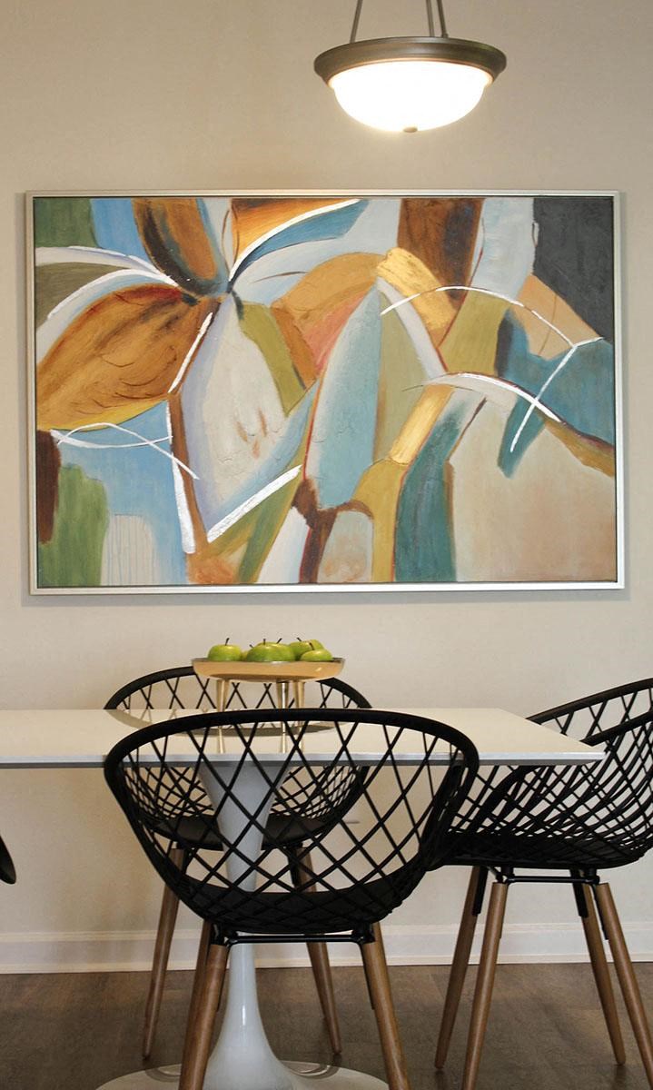 a table and chairs with a painting on the wall