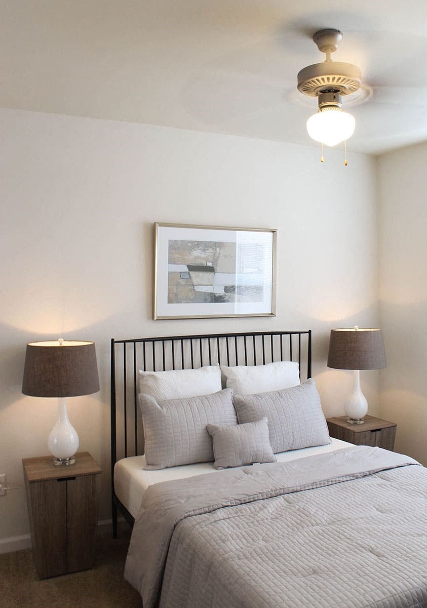 a bedroom with a bed and two lamps and a picture