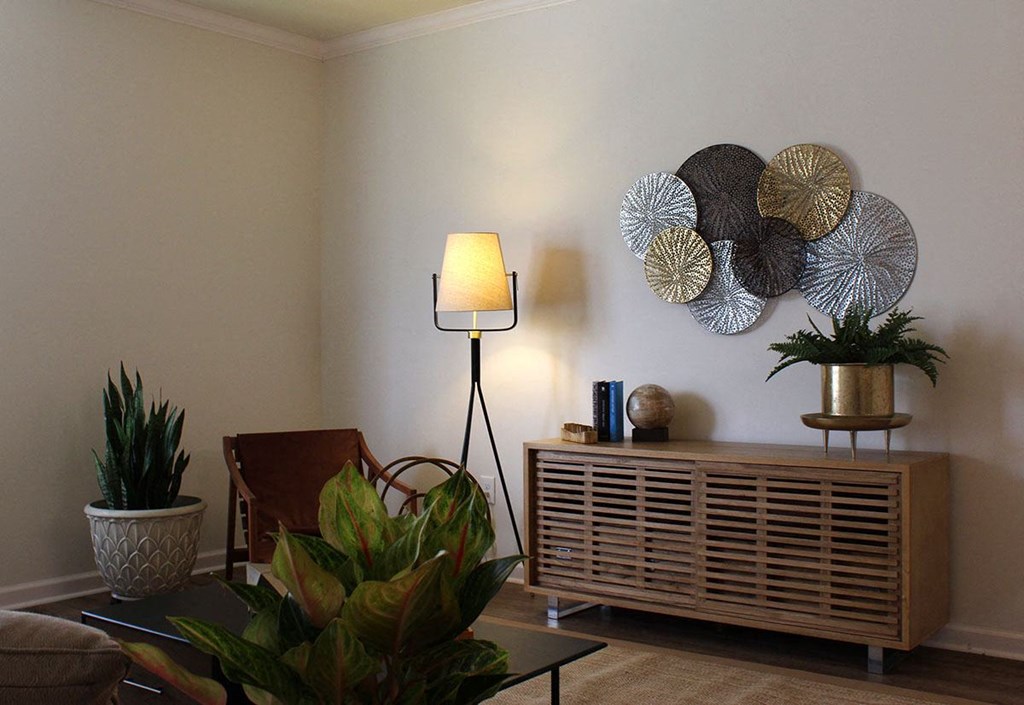 a living room with a lamp and some plates on the wall