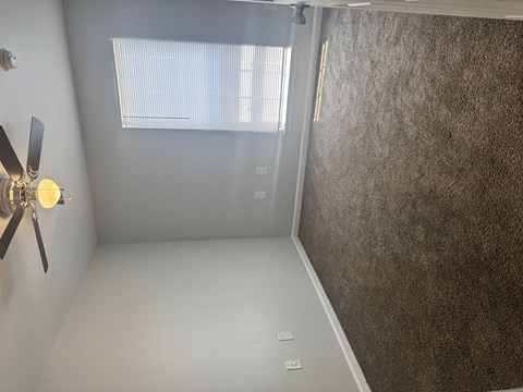 A room with a ceiling fan and a window.