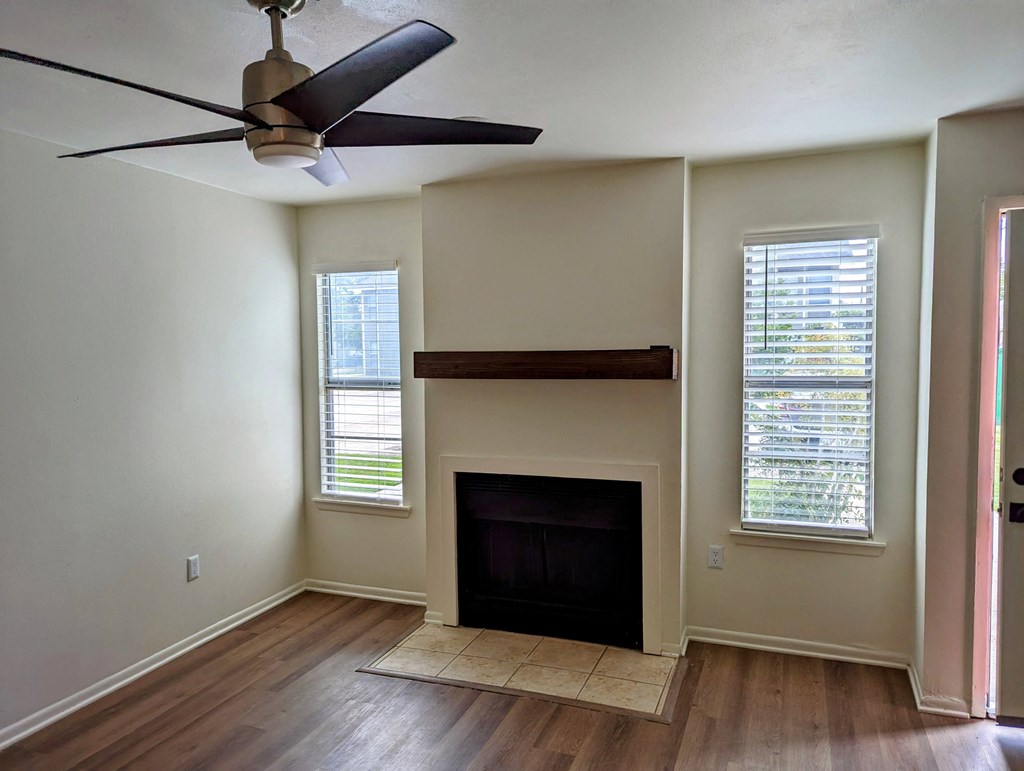 a living room with a fireplace and a ceiling fan