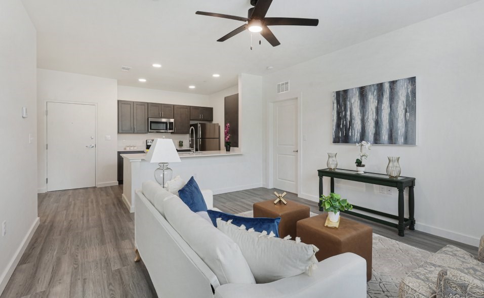 A living room with a white couch and a ceiling fan.