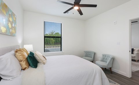 A bedroom with a large bed and a ceiling fan.