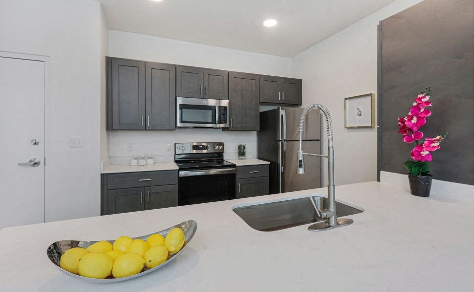 A kitchen with a bowl of lemons on the counter.