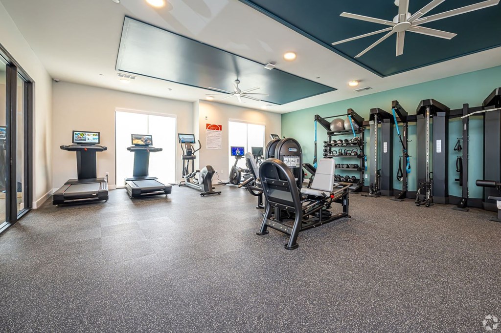 a gym with weights and cardio equipment at the apartments