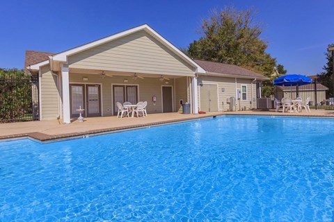A house with a blue pool in front.