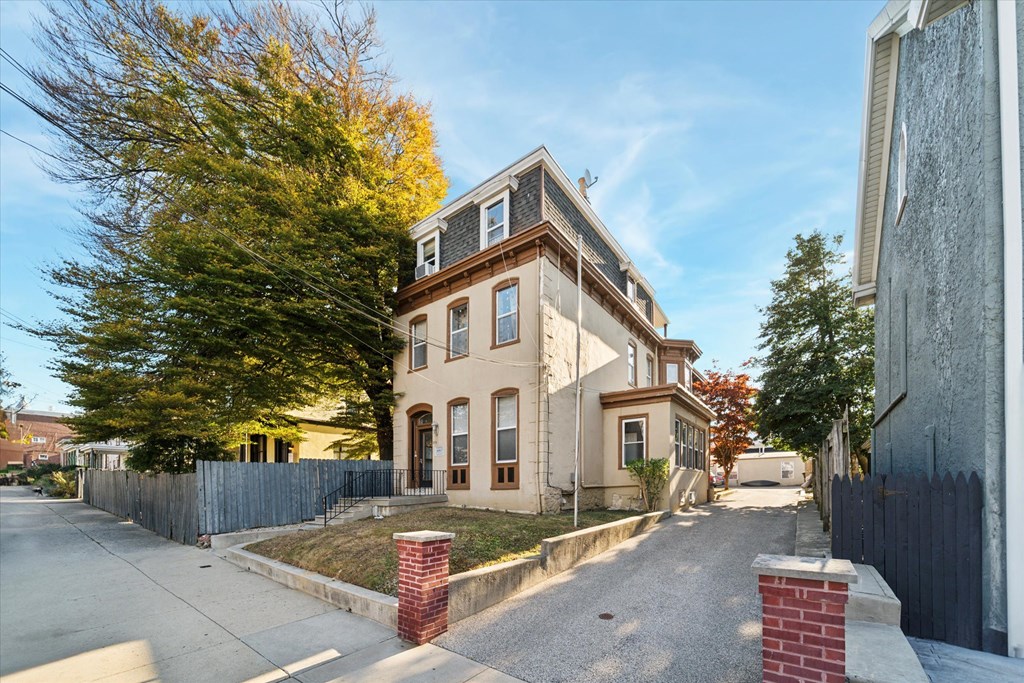 a house on the corner of a street with a sidewalk