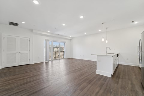 A spacious room with wooden floors and white walls.