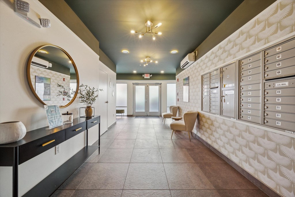 A hallway with a wall of mailboxes on the right side.