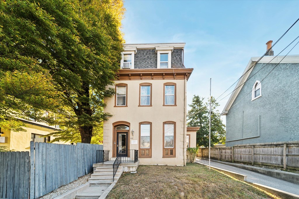 the front of a house with a yard and a fence