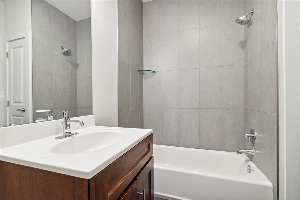 a bathroom with a sink and a tub and a mirror