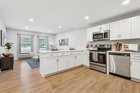 A modern kitchen with white cabinets and stainless steel appliances.