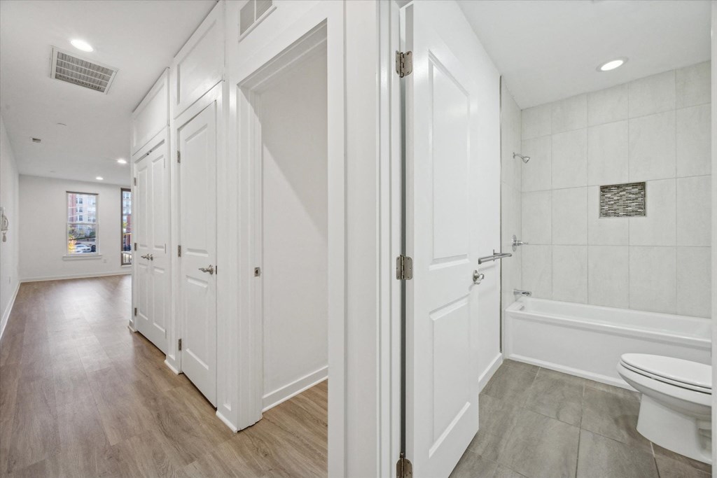 A white bathroom with a tub, toilet and sink.