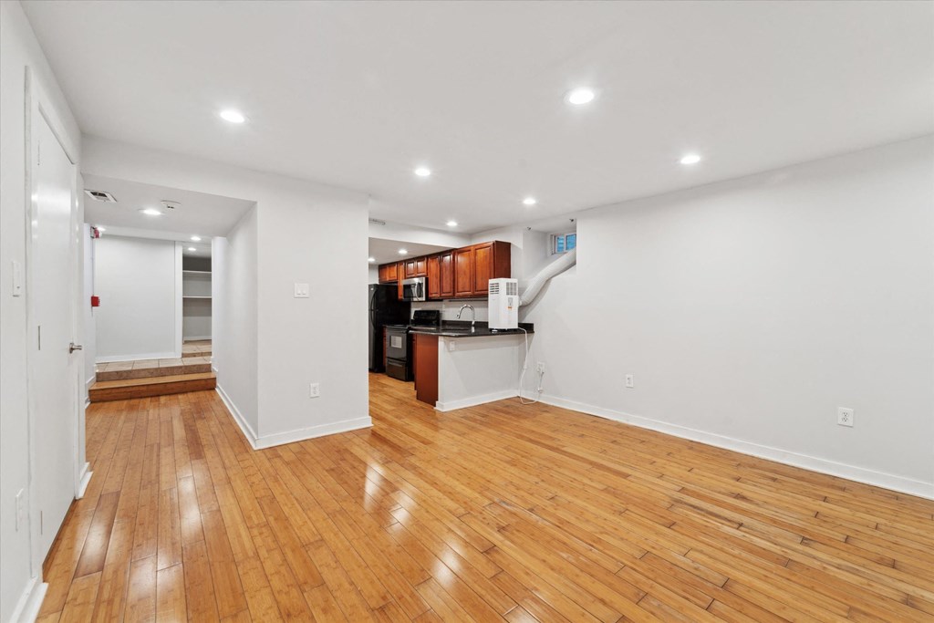 a living room with a hard wood floor and a kitchen