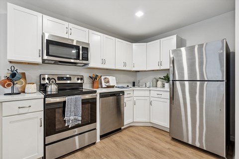 A kitchen with white cabinets and stainless steel appliances at Roosevelt Commons Apartments, Philadelphia, 19152
