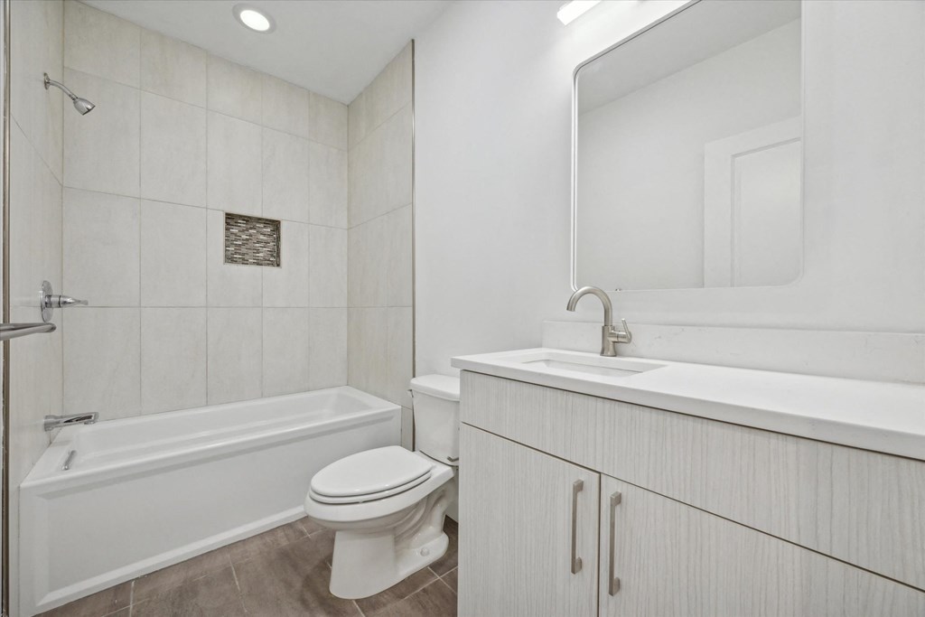 A white bathroom with a toilet, sink, and bathtub.