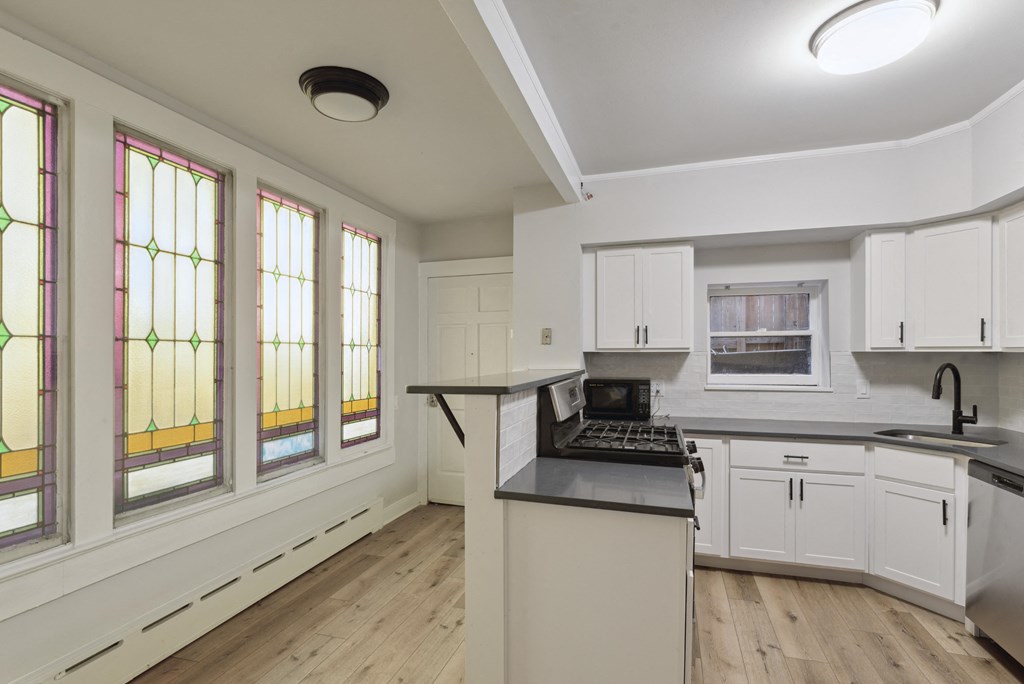 a kitchen with a stove top oven next to a window