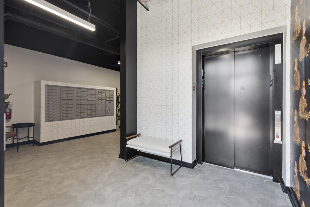 A room with a black door and a white bench.