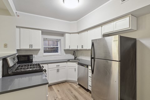 a kitchen with white cabinets and stainless steel appliances