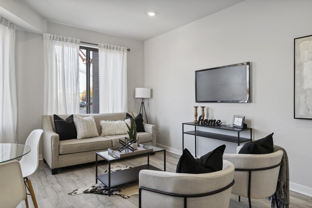 a living room with a couch and chairs and a television