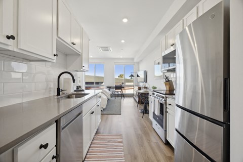 a large kitchen with stainless steel appliances and white cabinets