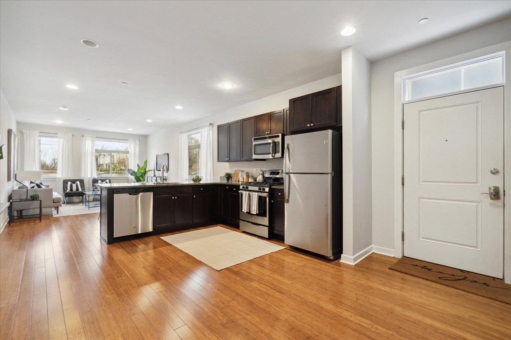 a kitchen with stainless steel appliances and wooden floors