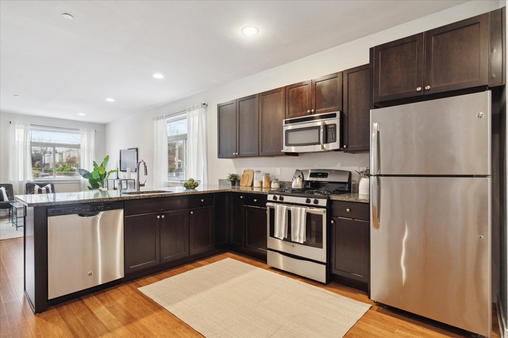 a kitchen with stainless steel appliances and dark wood cabinets