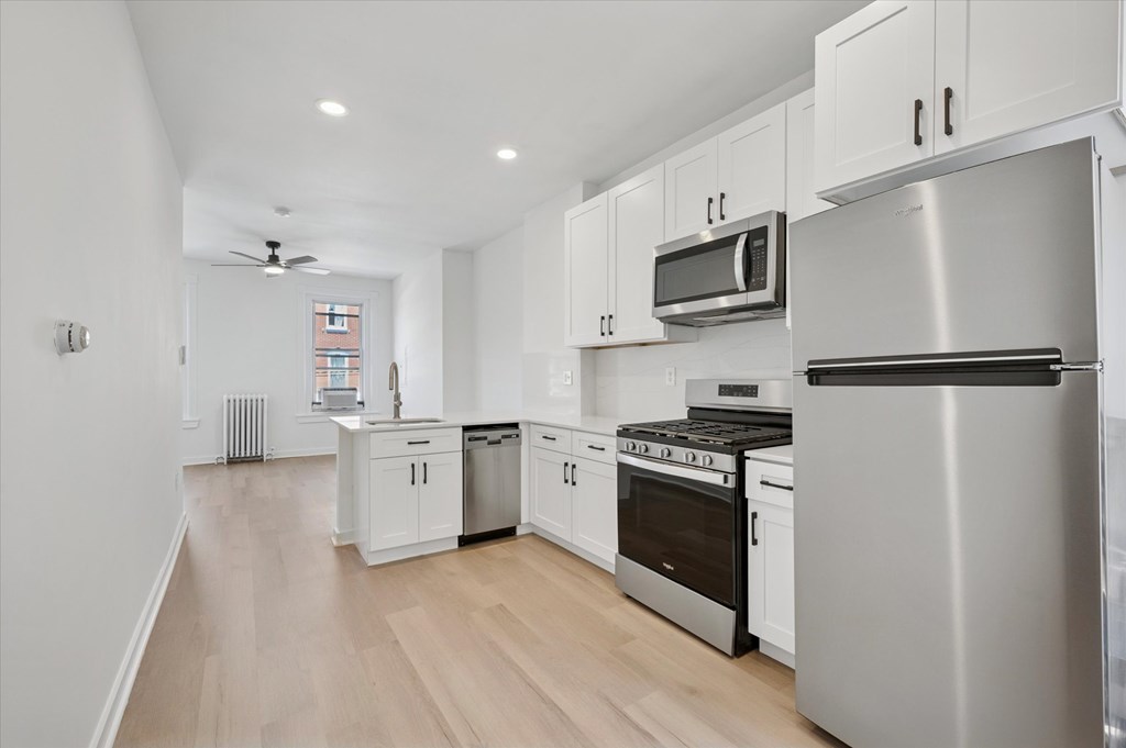 A modern kitchen with stainless steel appliances and white cabinets.